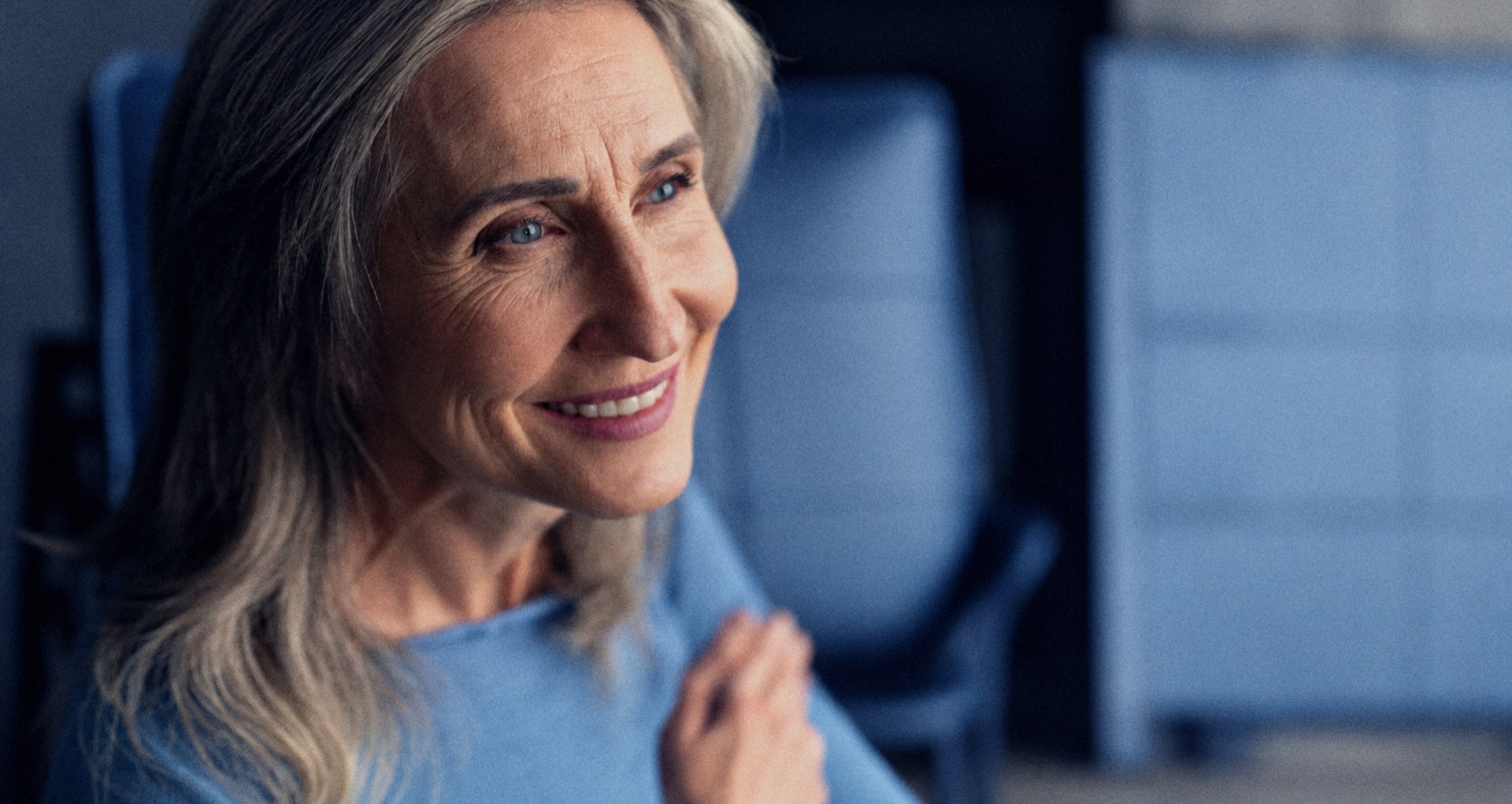 A smiling woman in natural window light